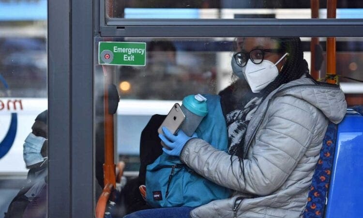 Woman wearing face covering on bus